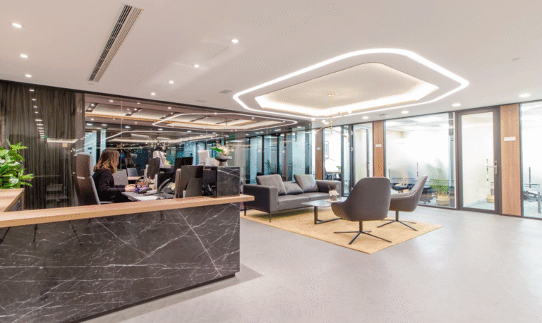 Reception area in a modern office with marble counter, lounge seating, and stylish ceiling lighting design.